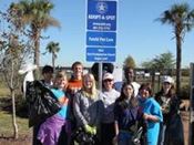Volunteers standing next to Adopt-a-Highway sign